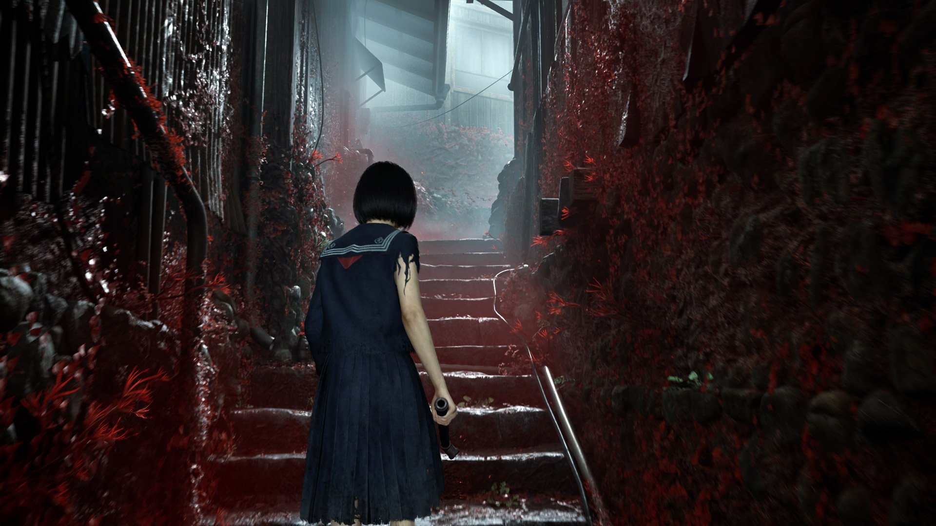 Hinako walks up a flight of stairs in a foggy environment while carrying a steel pipe.